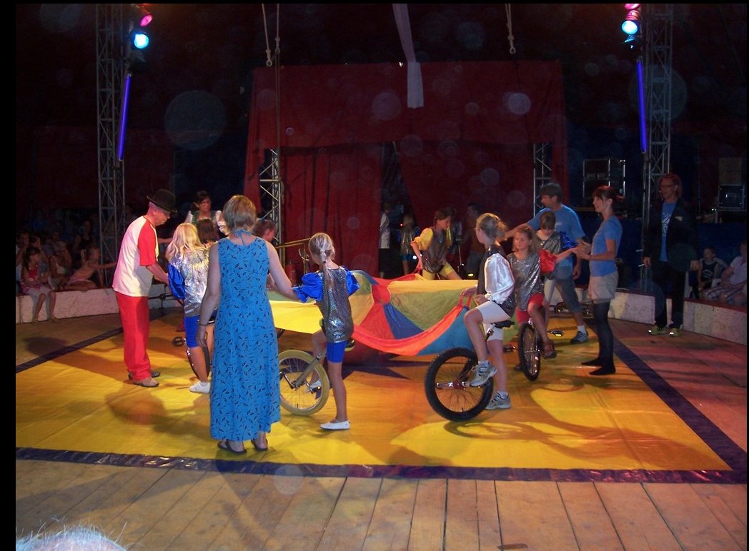 Kinder mit Einrädern bei der Kinderzirkus-Vorführung im Zelt